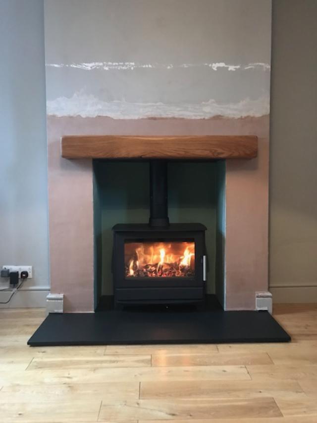 Wood burning stove with oak beam over. Installed Tunbridge Wells